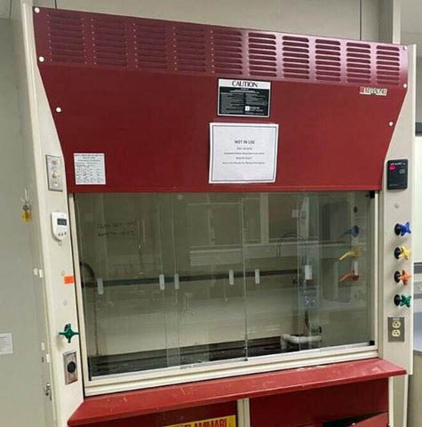 A 5 foot Kewaunee Supreme Air chemical fume hood package with a red bench top and clear glass sash, equipped with control knobs and cabinets.